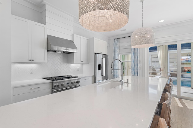 1016 Pathways Dr, Inlet Beach, FL 32461 - kitchen with wall chimney range hood, premium appliances, light countertops, wood finished floors, and white cabinets