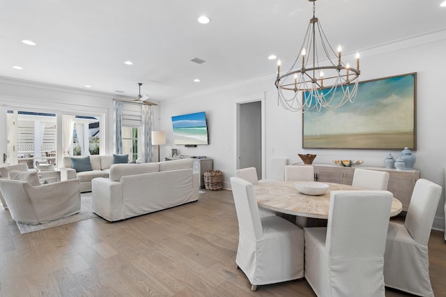 dining space with a notable chandelier, crown molding, and light hardwood / wood-style flooring