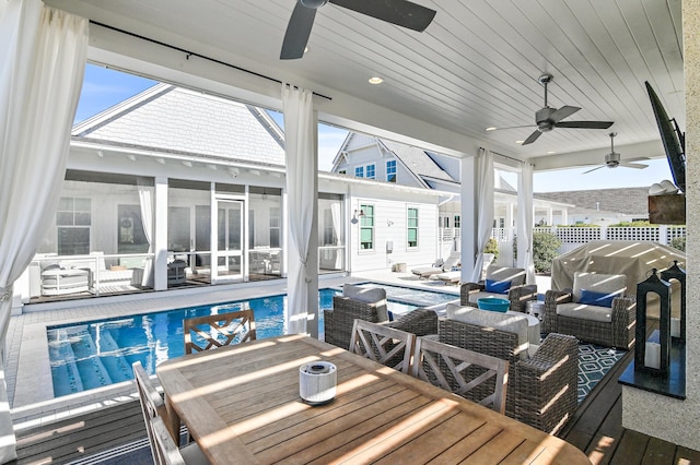 exterior space with a sunroom, an outdoor living space, ceiling fan, and a patio