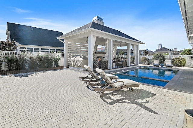 view of swimming pool with a gazebo, a patio, and an outdoor fireplace