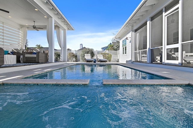 view of swimming pool featuring outdoor lounge area, ceiling fan, a patio area, and a sunroom