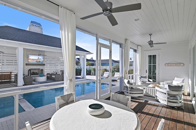 sunroom / solarium with ceiling fan and wood ceiling