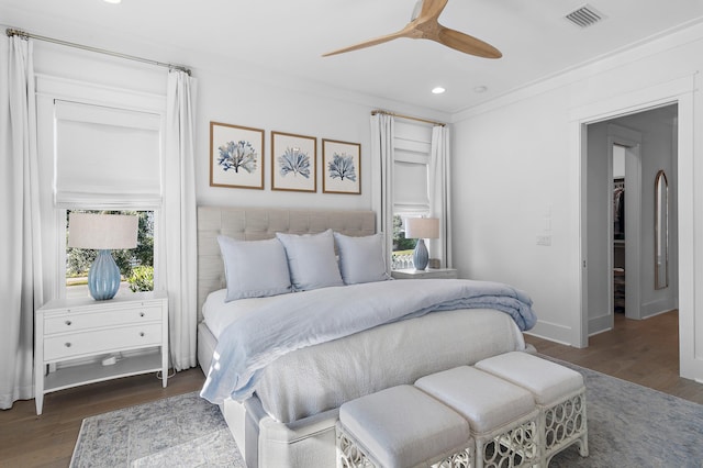 bedroom featuring multiple windows, dark hardwood / wood-style flooring, ceiling fan, and ornamental molding