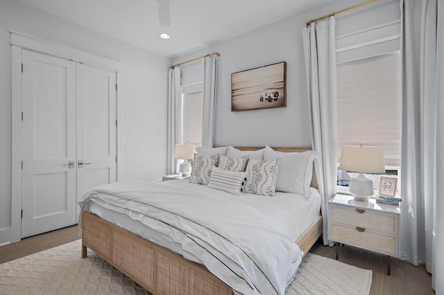 bedroom with wood-type flooring, a closet, and ceiling fan