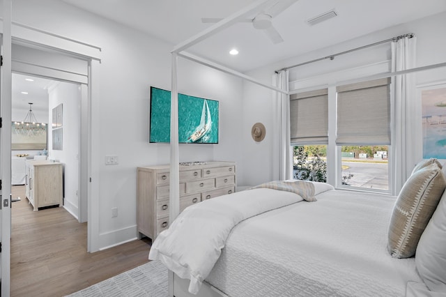 bedroom featuring washer / clothes dryer, ceiling fan, and hardwood / wood-style flooring