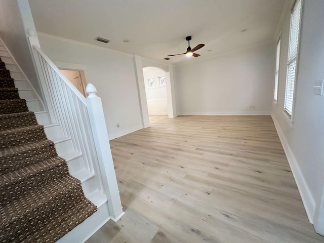 interior space featuring wood-type flooring, ceiling fan, and crown molding