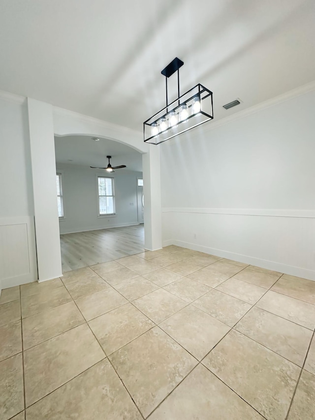 unfurnished dining area with ceiling fan, light wood-type flooring, and ornamental molding