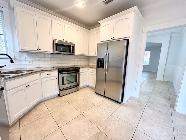 kitchen featuring white cabinets, stainless steel appliances, a healthy amount of sunlight, and sink