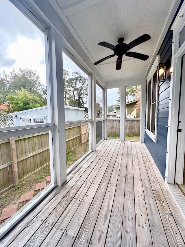 unfurnished sunroom featuring ceiling fan