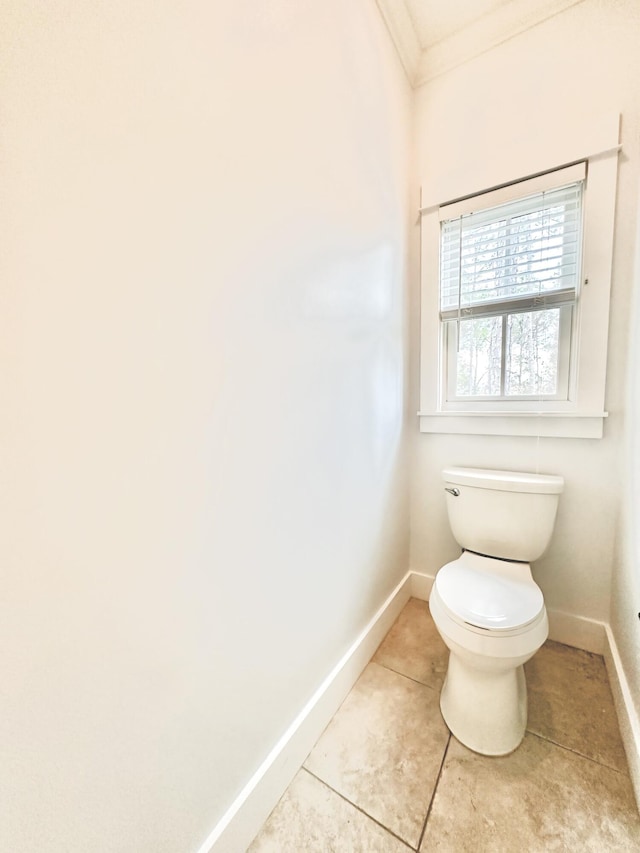 bathroom with tile patterned floors, toilet, and ornamental molding