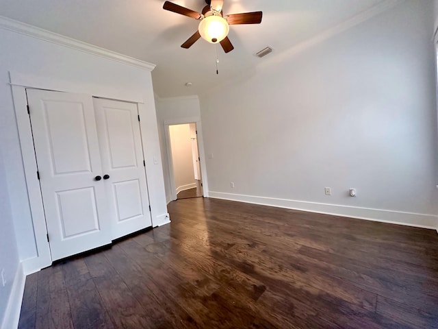 unfurnished bedroom with ceiling fan, crown molding, and dark wood-type flooring