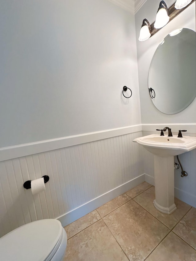 bathroom featuring tile patterned floors, toilet, and ornamental molding