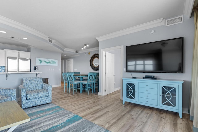 living room with ornamental molding and light hardwood / wood-style flooring