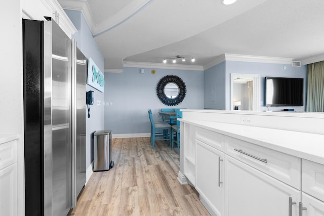 kitchen featuring track lighting, white cabinets, crown molding, stainless steel fridge, and light hardwood / wood-style floors