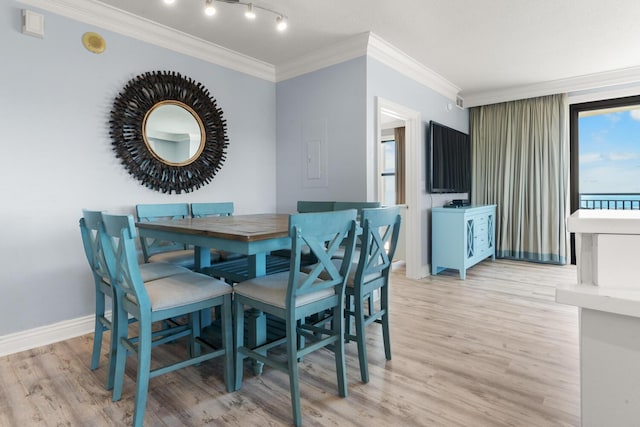 dining room featuring light wood-type flooring and ornamental molding