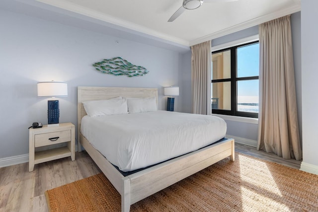 bedroom with ceiling fan, light wood-type flooring, and ornamental molding