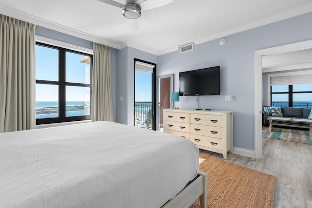 bedroom featuring light wood-type flooring, ornamental molding, access to outside, ceiling fan, and a water view