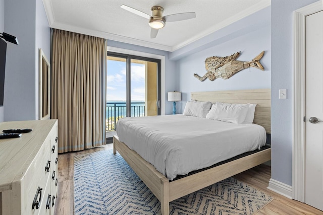 bedroom with ceiling fan, light hardwood / wood-style floors, access to outside, a water view, and ornamental molding