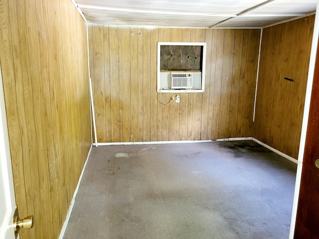 spare room featuring cooling unit and wood walls