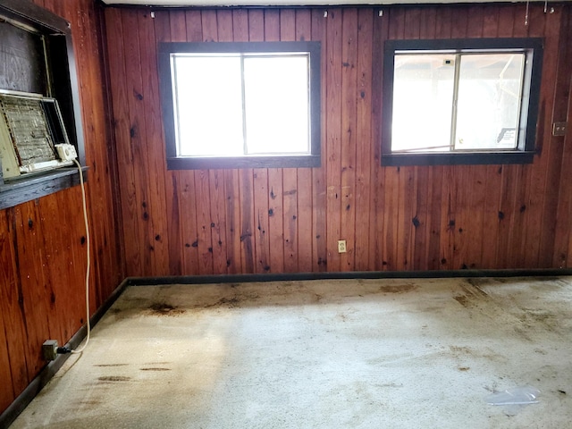 carpeted spare room with wood walls