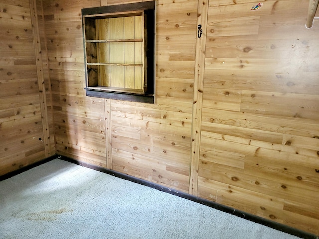 empty room with carpet flooring and wood walls