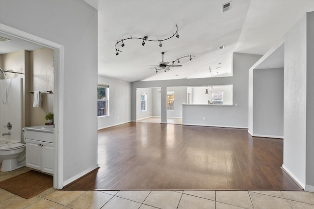 unfurnished living room featuring ceiling fan, lofted ceiling, and light wood-type flooring