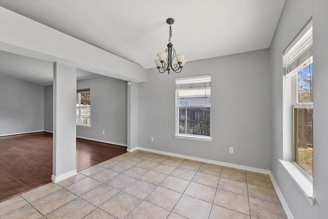 unfurnished room featuring light hardwood / wood-style floors and an inviting chandelier