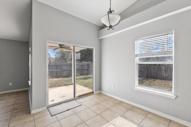 unfurnished dining area featuring vaulted ceiling, ceiling fan, a healthy amount of sunlight, and light tile patterned flooring