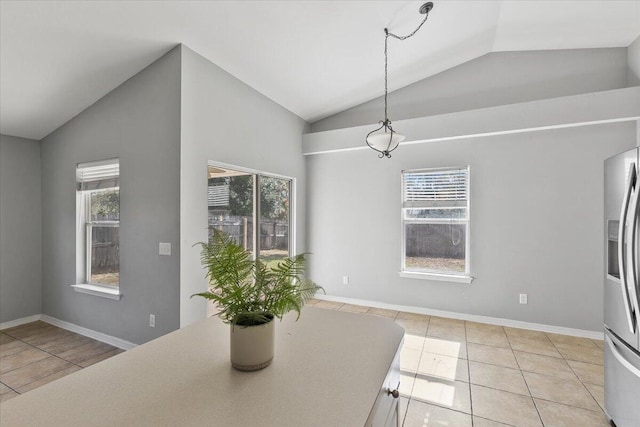 dining space with light tile patterned floors and vaulted ceiling