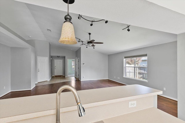 kitchen with ceiling fan, sink, dark hardwood / wood-style floors, and vaulted ceiling