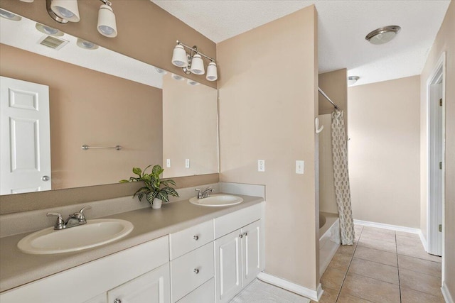 bathroom with a textured ceiling, vanity, tile patterned floors, and shower / bath combo with shower curtain