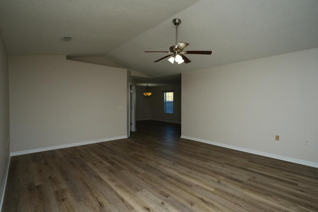 empty room with a textured ceiling, ceiling fan, lofted ceiling, and dark wood-type flooring