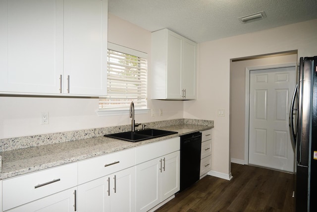 kitchen featuring sink, light stone counters, a textured ceiling, white cabinets, and black appliances