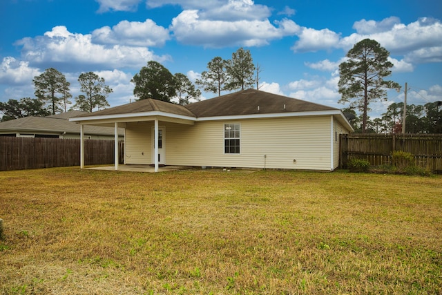 rear view of house with a yard and a patio