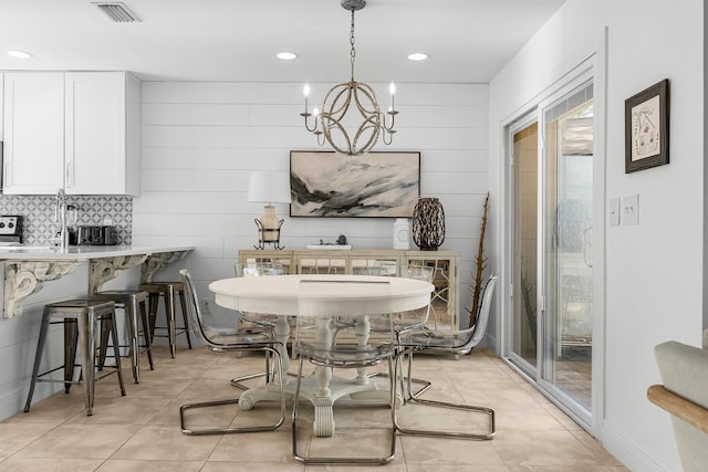 tiled dining space featuring an inviting chandelier