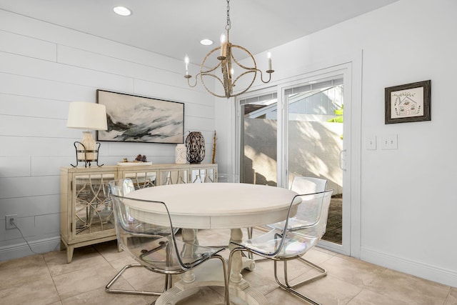 dining room featuring wood walls, light tile patterned floors, and a chandelier