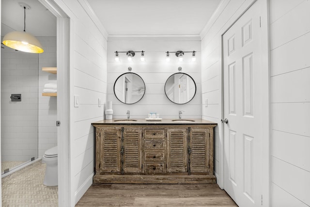 bathroom featuring toilet, vanity, wood-type flooring, and ornamental molding