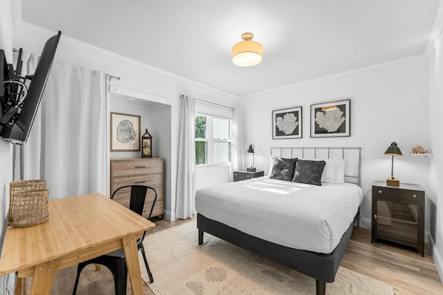 bedroom featuring ornamental molding and light wood-type flooring