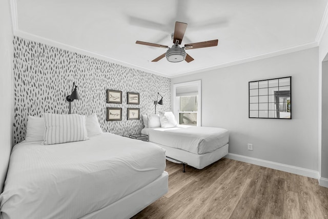 bedroom featuring hardwood / wood-style flooring, ceiling fan, and crown molding