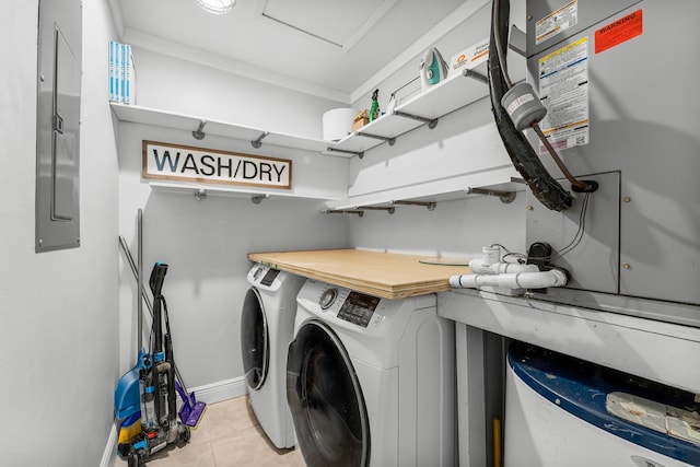 washroom with light tile patterned floors, electric panel, and washing machine and clothes dryer