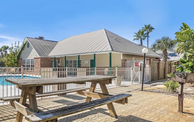 back of house with a fenced in pool and a patio area