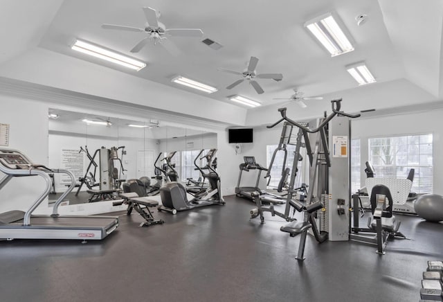 gym featuring a tray ceiling and ceiling fan