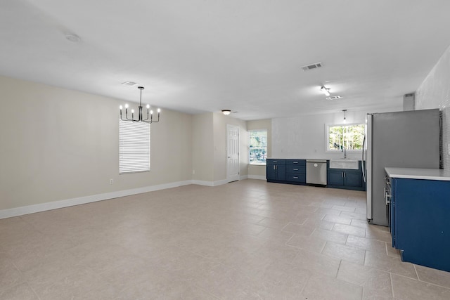 unfurnished living room featuring light tile patterned floors, an inviting chandelier, and sink