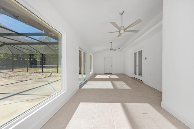 unfurnished sunroom with ceiling fan, a healthy amount of sunlight, lofted ceiling, and french doors