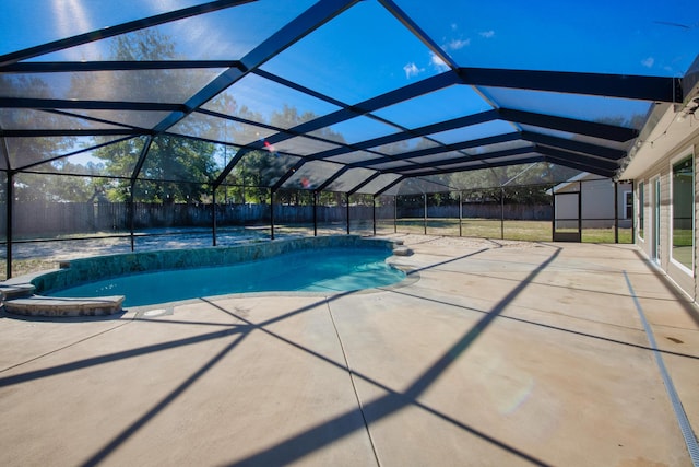 view of pool featuring glass enclosure and a patio