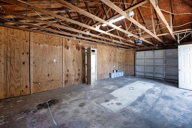 garage with wooden walls and a garage door opener