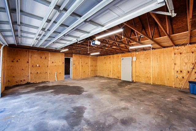 garage featuring wood walls and a garage door opener