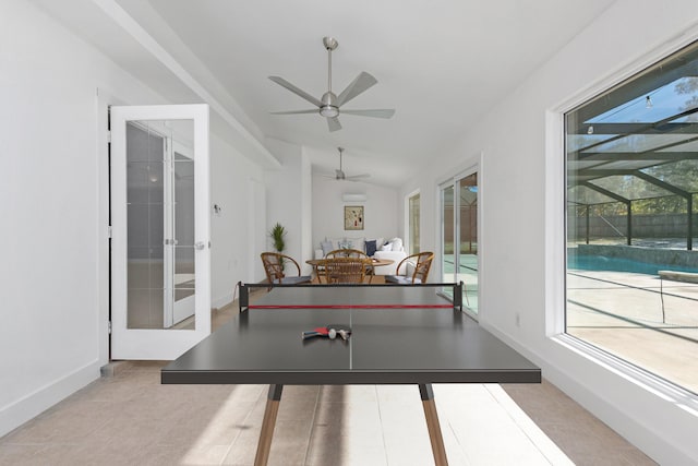 rec room with a wealth of natural light, light tile patterned flooring, vaulted ceiling, and ceiling fan