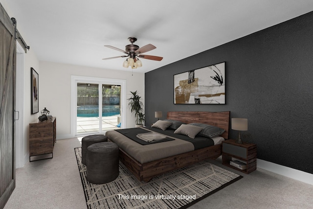 carpeted bedroom with ceiling fan, a barn door, and access to outside