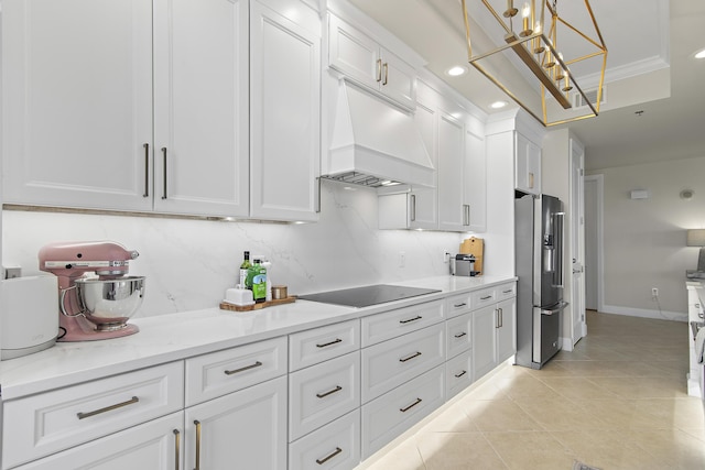 kitchen featuring white cabinets, stainless steel fridge, black electric stovetop, and premium range hood